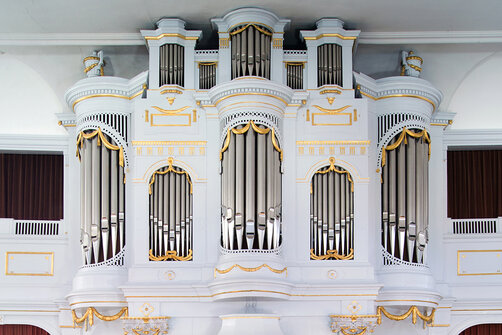 weiße Orgel mit silbernen Orgelpfeifen, hoch oben unter der Decke
